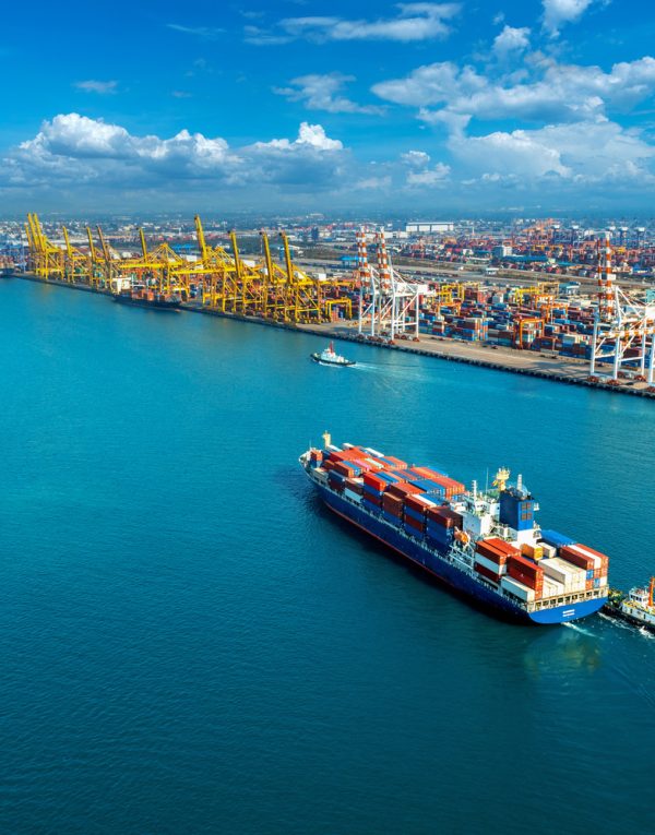 Aerial view of cargo ship and cargo container in harbor.